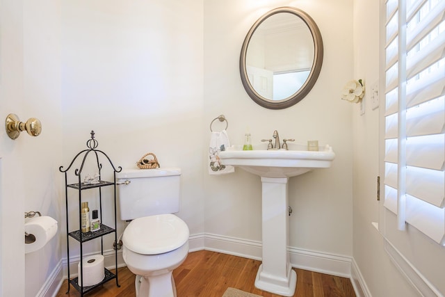 bathroom featuring baseboards, toilet, and wood finished floors