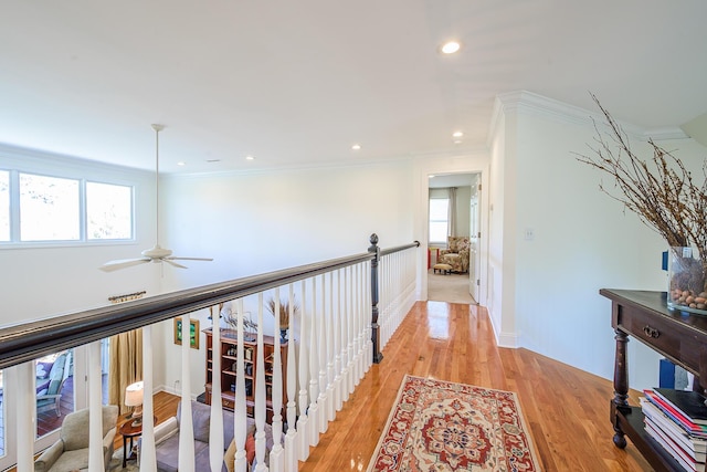 hallway with light wood finished floors, recessed lighting, crown molding, and baseboards