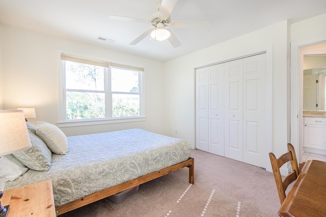 bedroom featuring a closet, light colored carpet, visible vents, and a ceiling fan