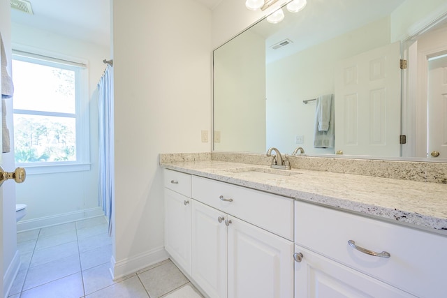 bathroom with visible vents, toilet, vanity, and tile patterned flooring