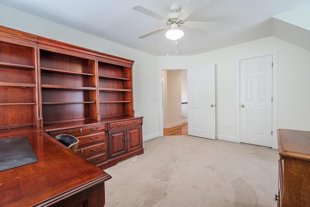 office space featuring baseboards, light carpet, and a ceiling fan