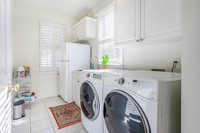 laundry area featuring baseboards, washing machine and dryer, light tile patterned floors, cabinet space, and a sink