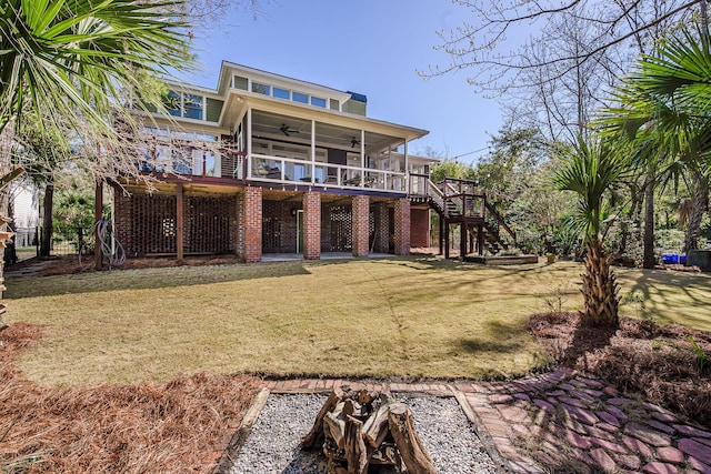 back of property with brick siding, fence, stairs, a yard, and a ceiling fan