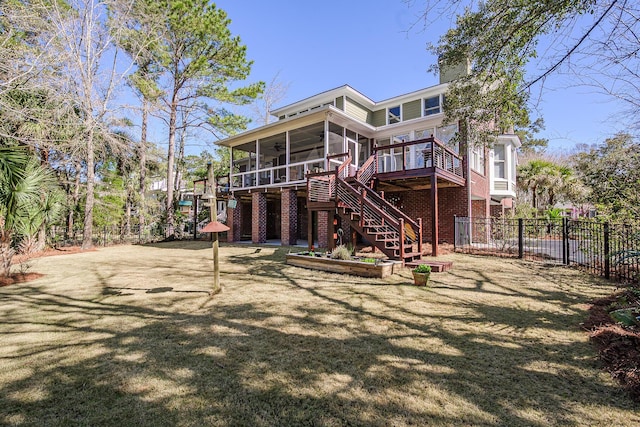 rear view of house featuring fence, brick siding, stairs, and a sunroom