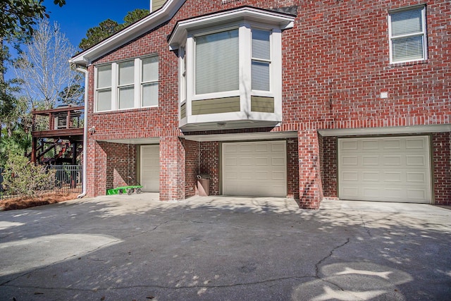 townhome / multi-family property featuring brick siding, driveway, and an attached garage