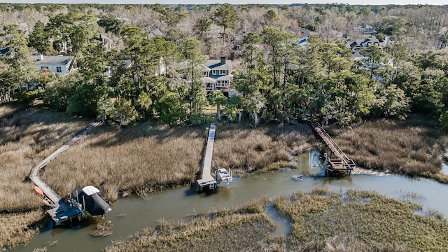 drone / aerial view featuring a wooded view and a water view