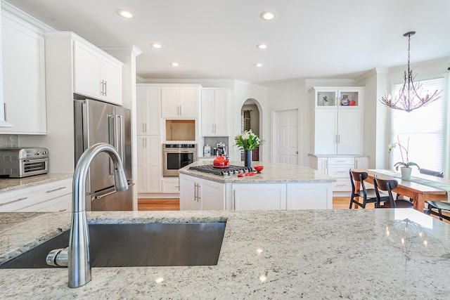 kitchen featuring a sink, tasteful backsplash, appliances with stainless steel finishes, and white cabinets