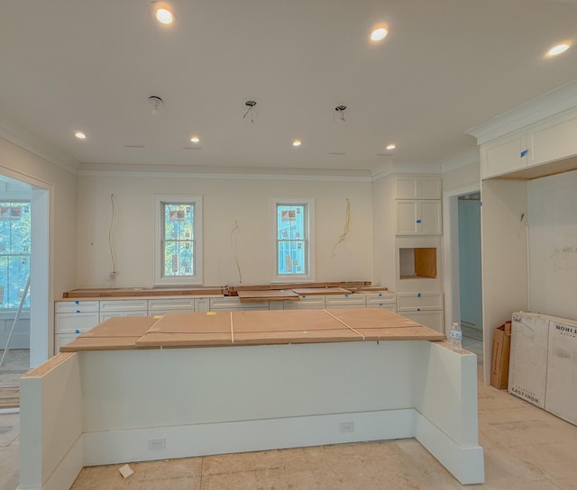 kitchen featuring recessed lighting, a large island, ornamental molding, and white cabinetry