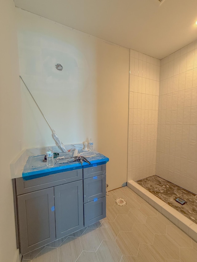 bathroom featuring a tile shower and vanity