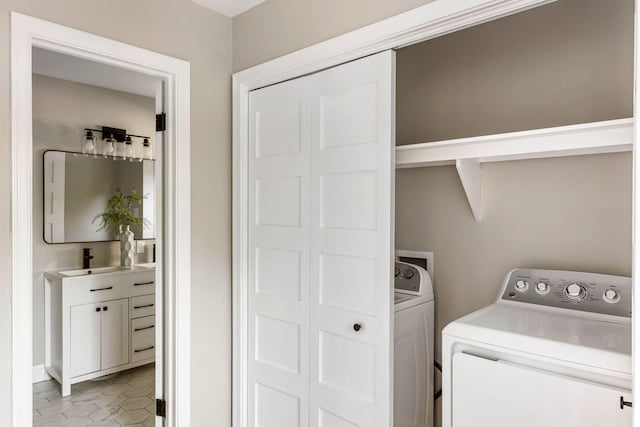 laundry area with independent washer and dryer, light tile patterned floors, and sink