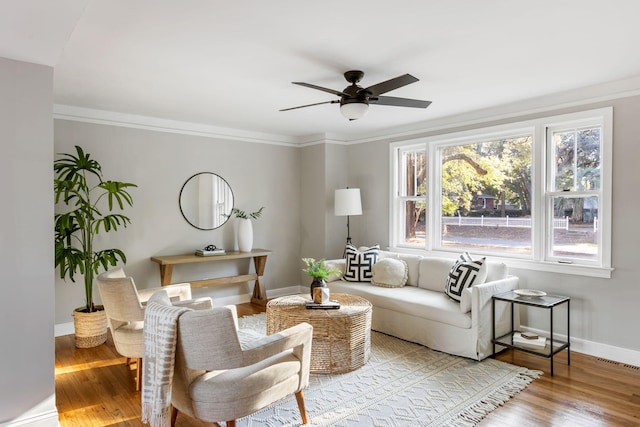 living room featuring ceiling fan, light hardwood / wood-style floors, and ornamental molding