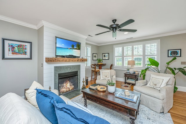 living area featuring ornamental molding, baseboards, a fireplace with flush hearth, and wood finished floors