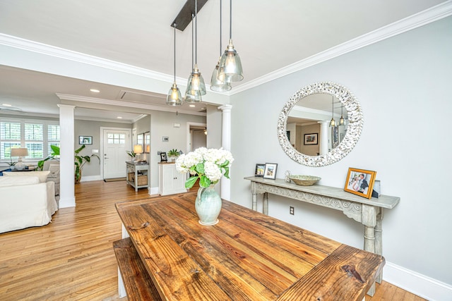 dining space with baseboards, crown molding, wood finished floors, and ornate columns