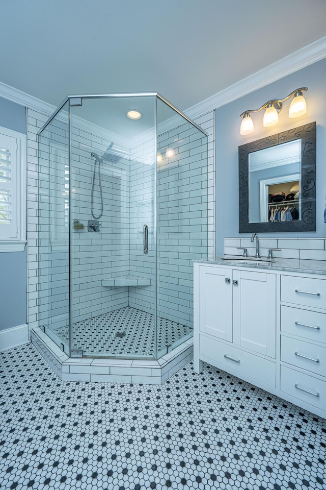 full bath featuring a stall shower, tile patterned floors, ornamental molding, and vanity