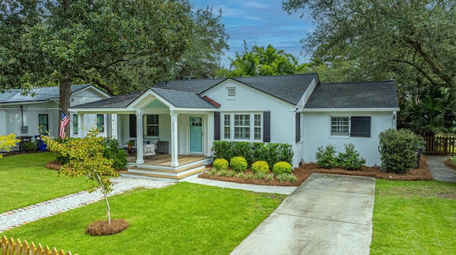 ranch-style house with a shingled roof, fence, a porch, and a front yard