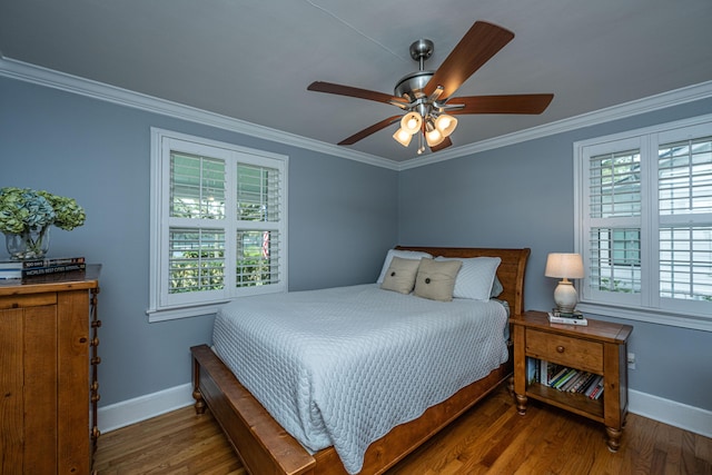 bedroom featuring baseboards, wood finished floors, and crown molding