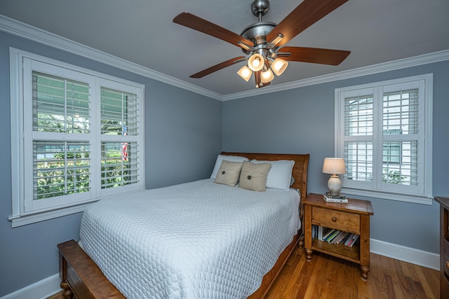 bedroom featuring ceiling fan, crown molding, baseboards, and wood finished floors