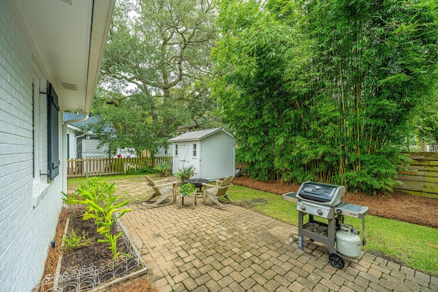 view of patio / terrace with a grill, a storage unit, a fenced backyard, and an outdoor structure