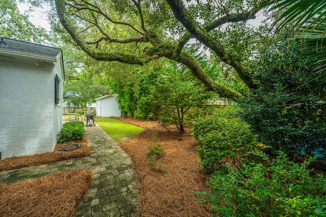 view of yard featuring fence and an outbuilding