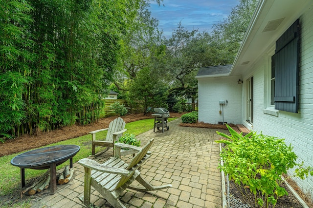 view of patio / terrace with fence, a fire pit, and grilling area