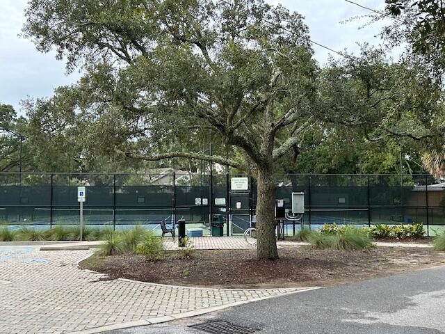 view of property's community with a tennis court and fence