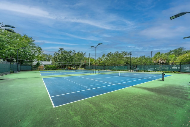 view of tennis court featuring fence