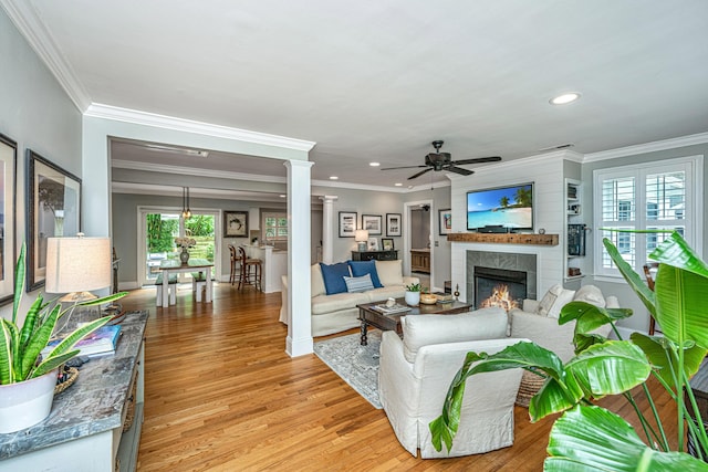 living room featuring recessed lighting, light wood-style floors, a ceiling fan, a lit fireplace, and baseboards