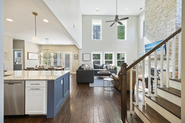 1166 Turkey Trot Dr, Johns Island, SC 29455 - kitchen with stainless steel dishwasher, dark wood-style flooring, open floor plan, white cabinetry, and light stone countertops