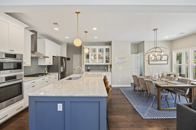 1166 Turkey Trot Dr, Johns Island, SC 29455 - kitchen with wall chimney exhaust hood, stainless steel appliances, a sink, backsplash, and glass insert cabinets