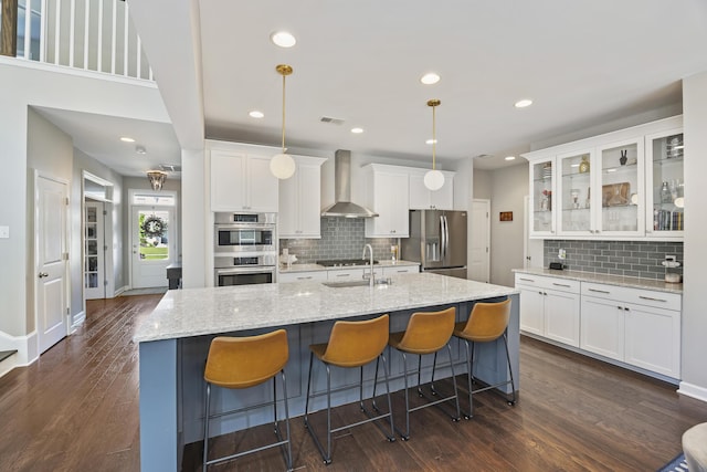 1166 Turkey Trot Dr, Johns Island, SC 29455 - kitchen with an island with sink, wall chimney exhaust hood, appliances with stainless steel finishes, and white cabinetry