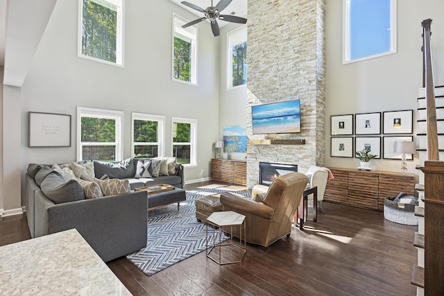 1166 Turkey Trot Dr, Johns Island, SC 29455 - living area featuring a stone fireplace, dark wood-style flooring, a towering ceiling, and a ceiling fan