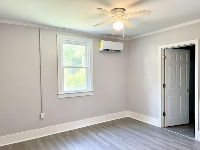 spare room with crown molding, ceiling fan, wood-type flooring, and a wall mounted air conditioner