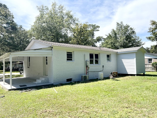 rear view of house featuring a lawn and a carport