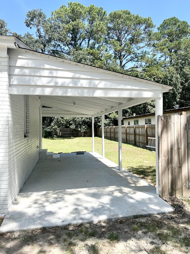 view of vehicle parking featuring a yard and a carport