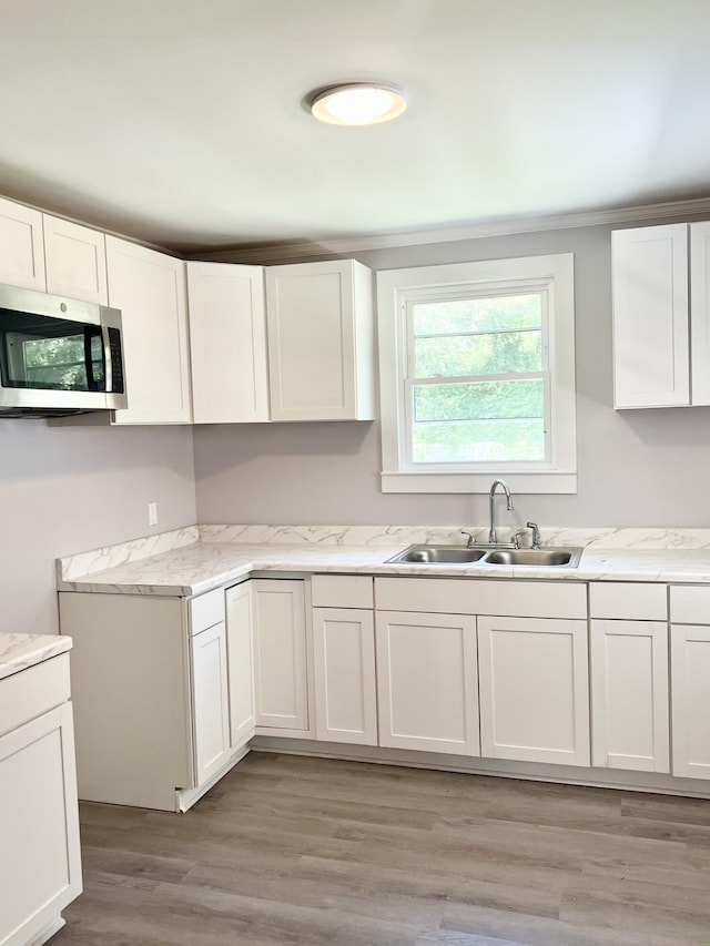 kitchen featuring sink, white cabinets, and light hardwood / wood-style floors