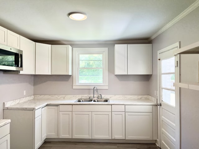 kitchen with ornamental molding, dark wood-type flooring, sink, and white cabinetry