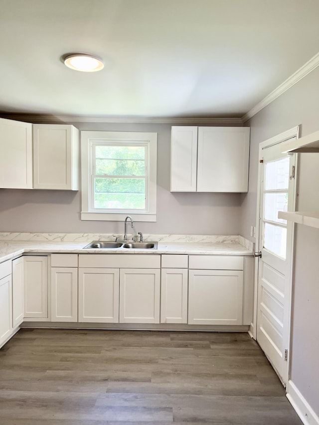 kitchen featuring light wood-type flooring, white cabinetry, and sink