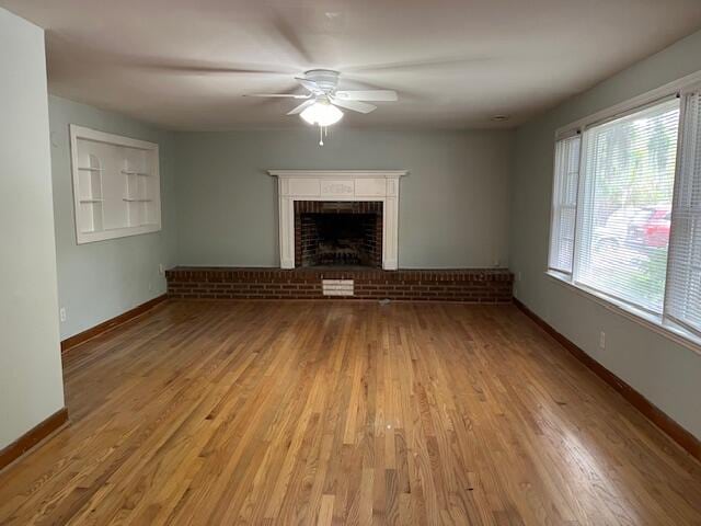 unfurnished living room with a fireplace, light hardwood / wood-style flooring, and ceiling fan