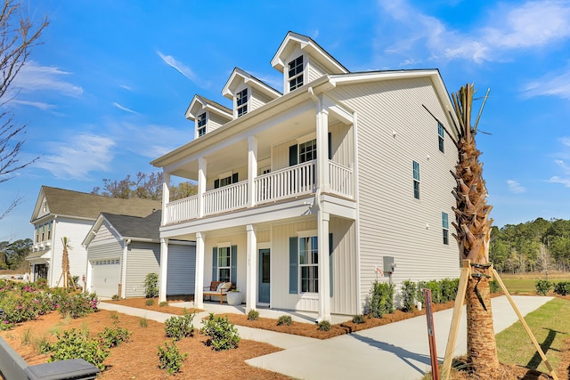 view of front of home with covered porch, a balcony, and a garage