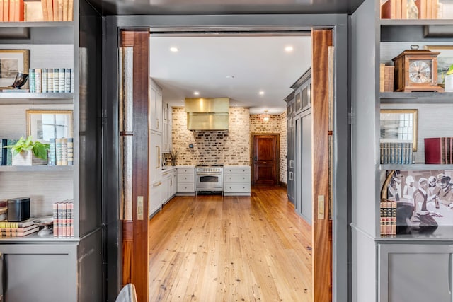 kitchen featuring white cabinetry, light hardwood / wood-style flooring, high end range, and a healthy amount of sunlight