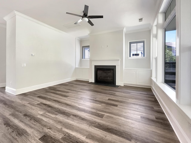 unfurnished living room with crown molding, dark wood finished floors, a ceiling fan, a fireplace with flush hearth, and visible vents