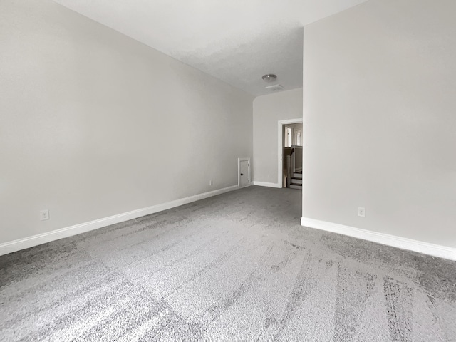 carpeted spare room with baseboards