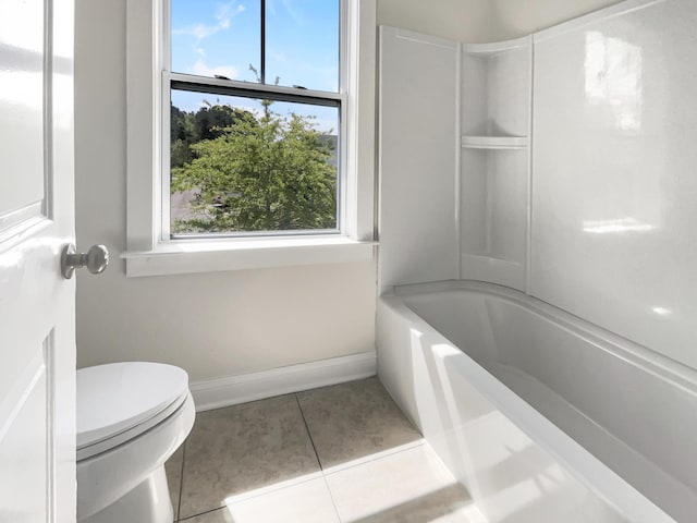 bathroom featuring baseboards, tile patterned flooring, and toilet