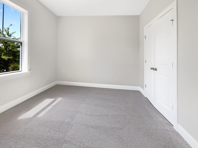 spare room with baseboards and carpet