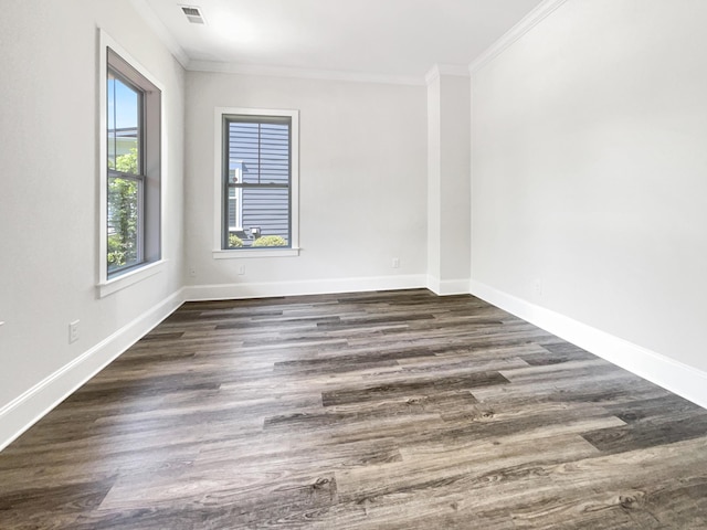 unfurnished room featuring visible vents, ornamental molding, baseboards, and wood finished floors