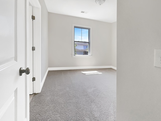 spare room with baseboards, carpet floors, and visible vents