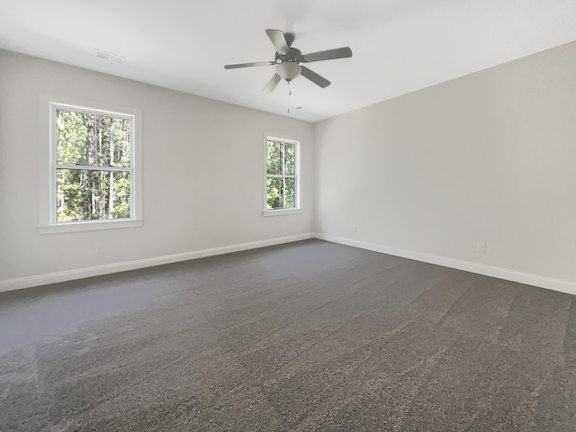 spare room with baseboards, ceiling fan, and visible vents