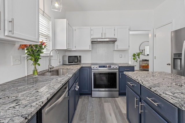 3202 Middleburry Ln, Charleston, SC 29414 - kitchen with appliances with stainless steel finishes, blue cabinetry, a sink, under cabinet range hood, and white cabinets