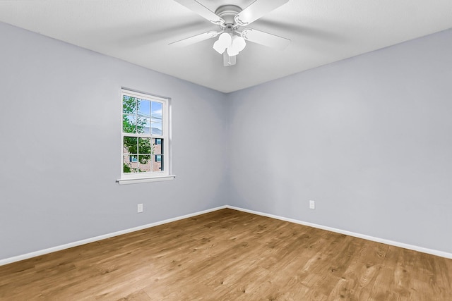 empty room with ceiling fan, light wood-style flooring, and baseboards