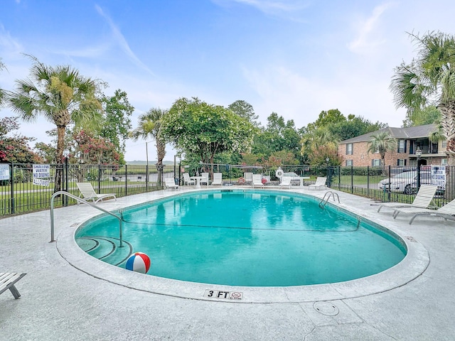 community pool featuring a patio area and fence